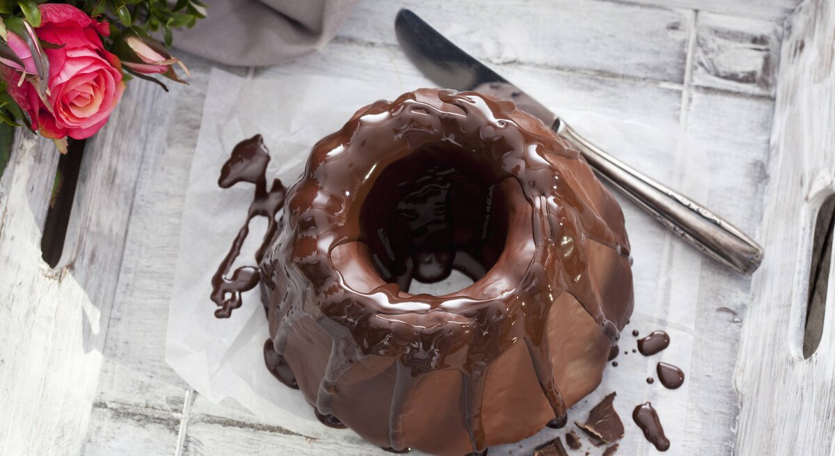 Ein Schokoladen-Kuchen von oben auf einem grauen Tisch fotografiert.