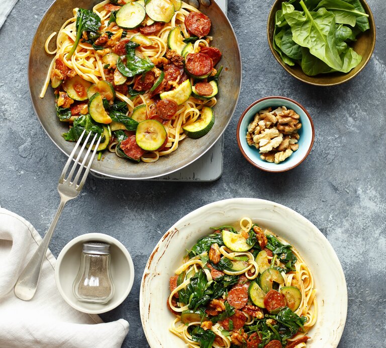 Linguine mit Chorizo und Zucchini auf eine grauen Telle ru ddunklem Tisch direkt von oben fotografiert. | © StockFood: Castilho, Rua