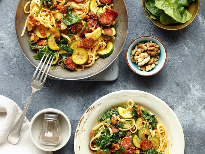 Linguine mit Chorizo und Zucchini auf eine grauen Telle ru ddunklem Tisch direkt von oben fotografiert. | © StockFood: Castilho, Rua
