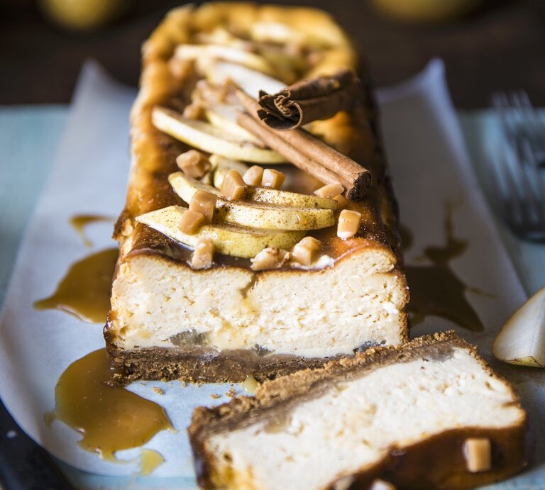 Der Toffee-Birnen-Käsekuchen angeschnitten auf einer bläulichen Serviette von vorne fotografiert. | © StockFood / Hendey, Magdalena