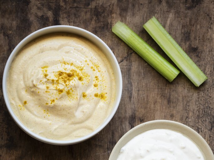 Curry-Dip mit Rohkost auf hölzernem Untergrund. | © GettyImages/Westend61