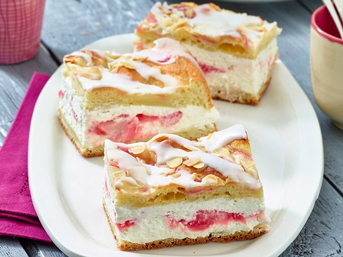Auf einem ovalen hellen Teller aus Porzellan sind drei Stücke Rhabarber-Kuchen | © Matthias Liebich
