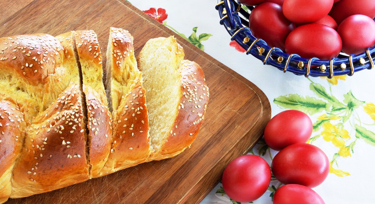 griechischer Osterzopf auf Holz mit roten Eiern