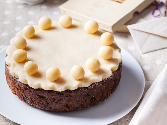 Runder Kuchen mit einer Marzipanschicht und runden Marzipan-Kugeln belegt.  | © iStock/AnnaPustynnikova