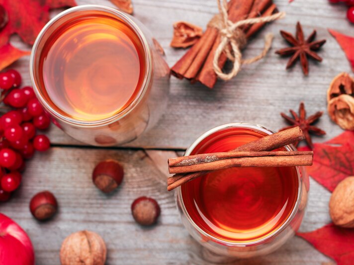 Rosé-Glühwein von oben, umrundet von weihnachtlichen Gewürzen und roter Deko.  | © Shutterstock/Antonina Vlasova