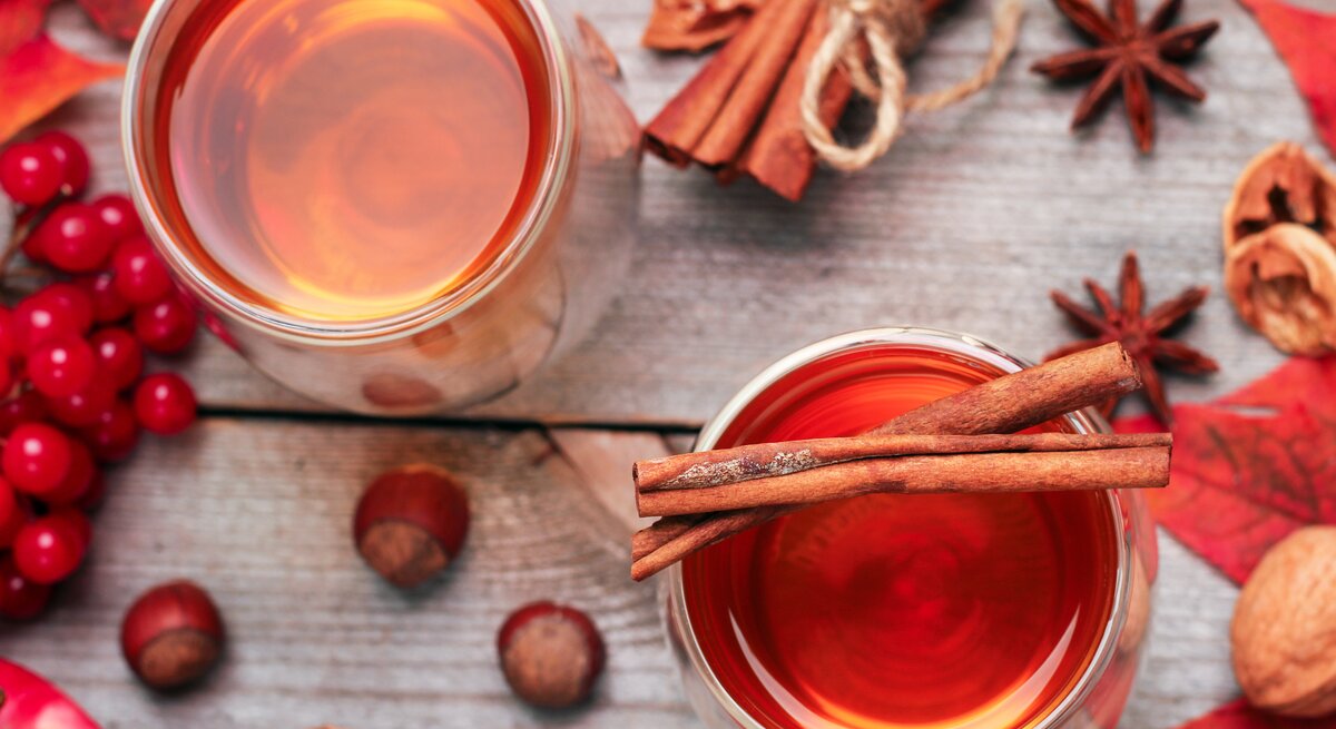 Rosé-Glühwein von oben, umrundet von weihnachtlichen Gewürzen und roter Deko. 
