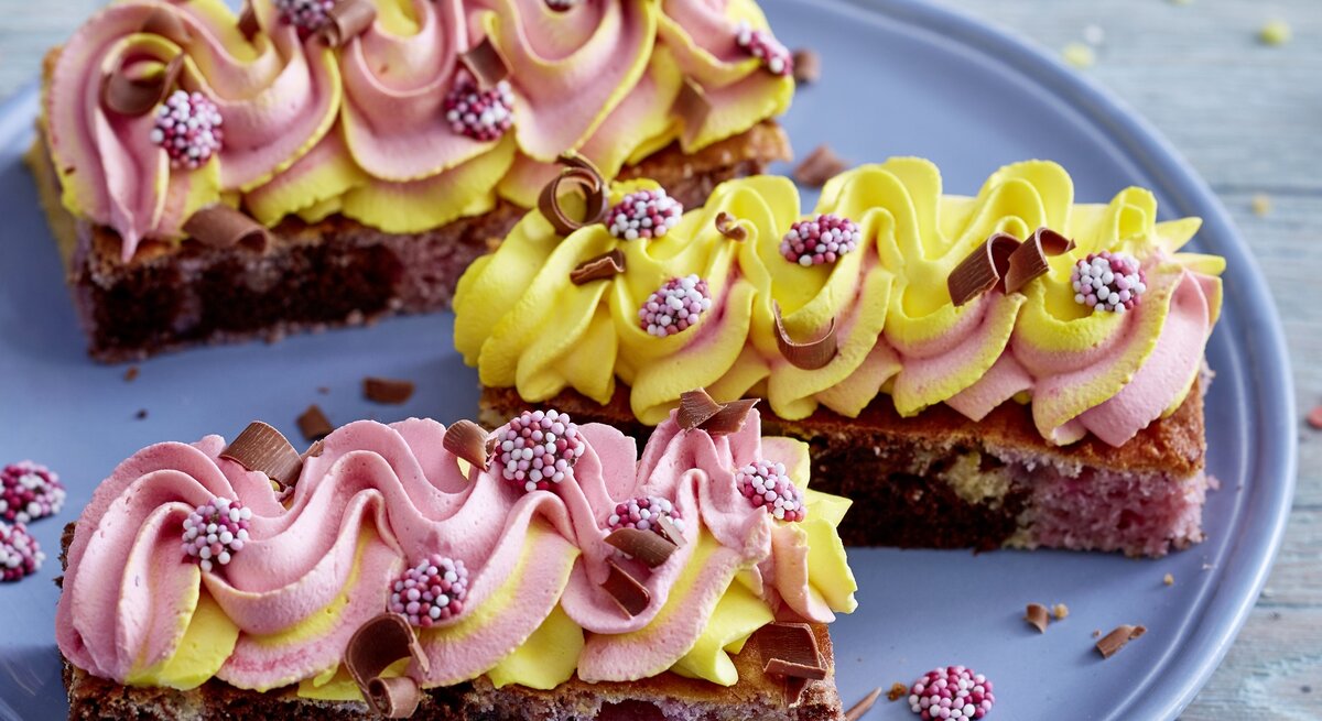 kunterbunter Marmorkuchen vom Blech / drei Stücke / runder Teller / Untergrund Holz