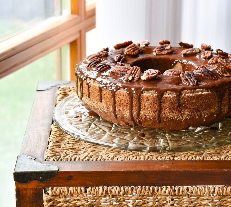 seitliche Ansicht auf einen runden Kuchen mit Glasur und Nüssen.  | © iStock.com/Angelika Heine