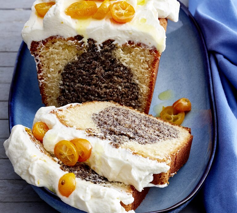 Mohn-Joghurt-Kuchen auf einem blauen Teller vor blauen Hintergrund. Rechts ein blaues Tuch.  | © EAT CLUB/Isabell Triemer