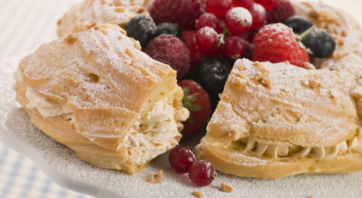 Seitliche Ansicht eines Paris Brest Kuchens, garniert mit Beeren.