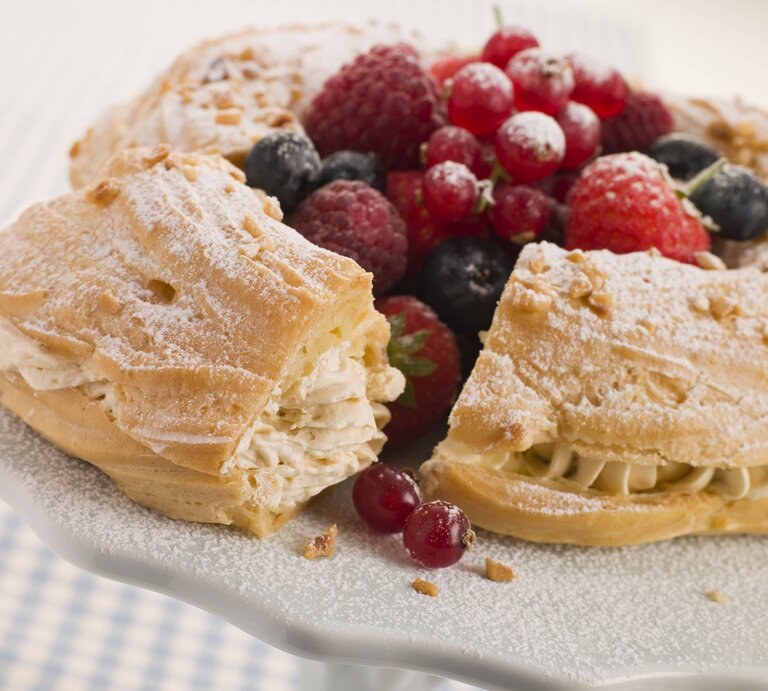 Seitliche Ansicht eines Paris Brest Kuchens, garniert mit Beeren. | © imago images/Shotshop
