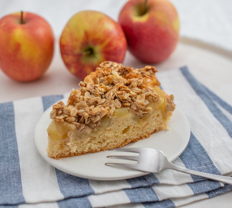 Ein Stück Apfelkuchen mit Haferflockentopping auf Teller. | © iStock.com/A_Lein 