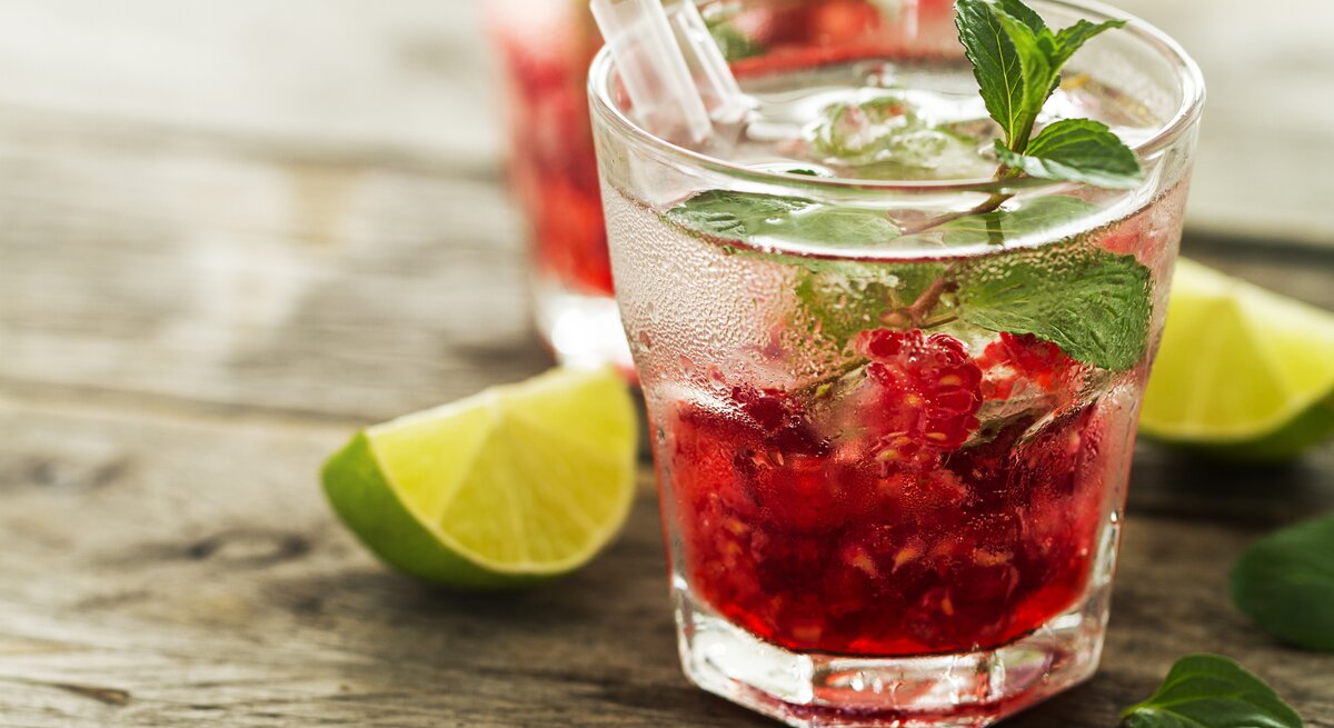 Seitliche Ansicht eines Glases mit Himbeer-Gin. | © iStock/nerudol