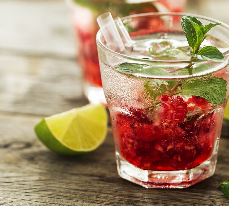 Seitliche Ansicht eines Glases mit Himbeer-Gin. | © iStock/nerudol
