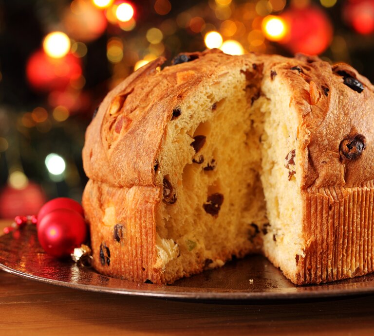 Angeschnittener Panettone vor weihnachtlichem Ambiente.  | © iStock/MKucova