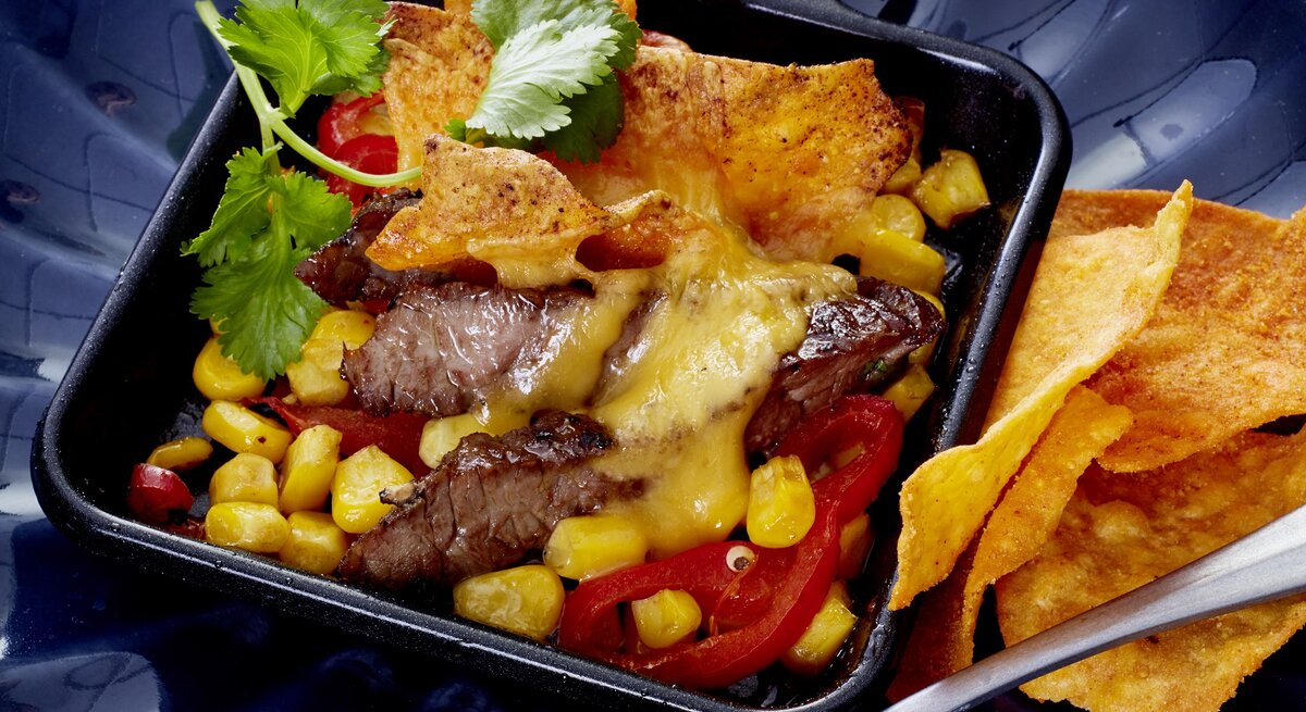 Steak Tortilla Pfännchen auf einem dunkelblauen Teller. 