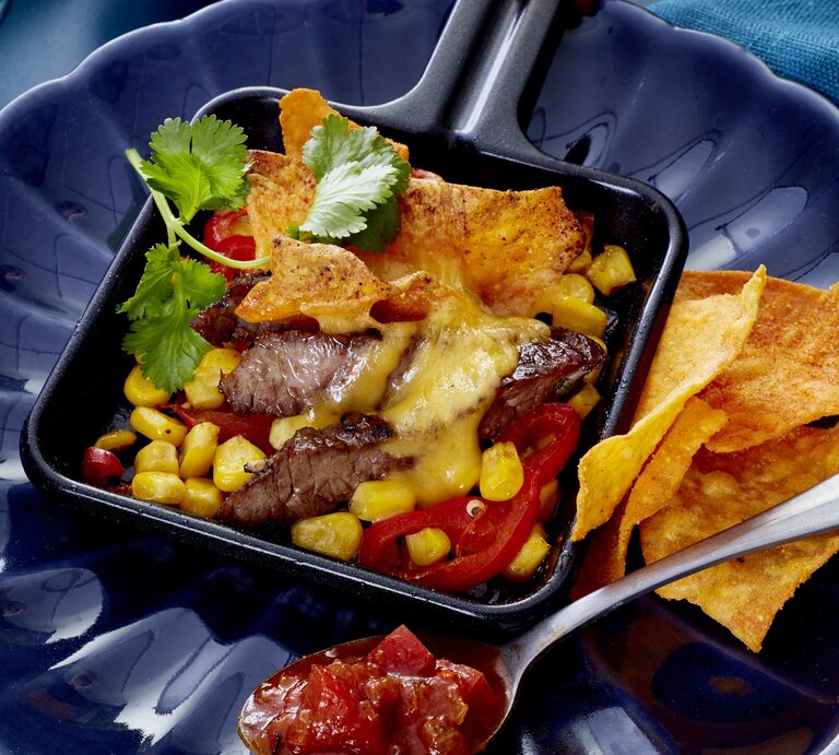 Steak Tortilla Pfännchen auf einem dunkelblauen Teller.  | © EAT CLUB/Isabell Triemer