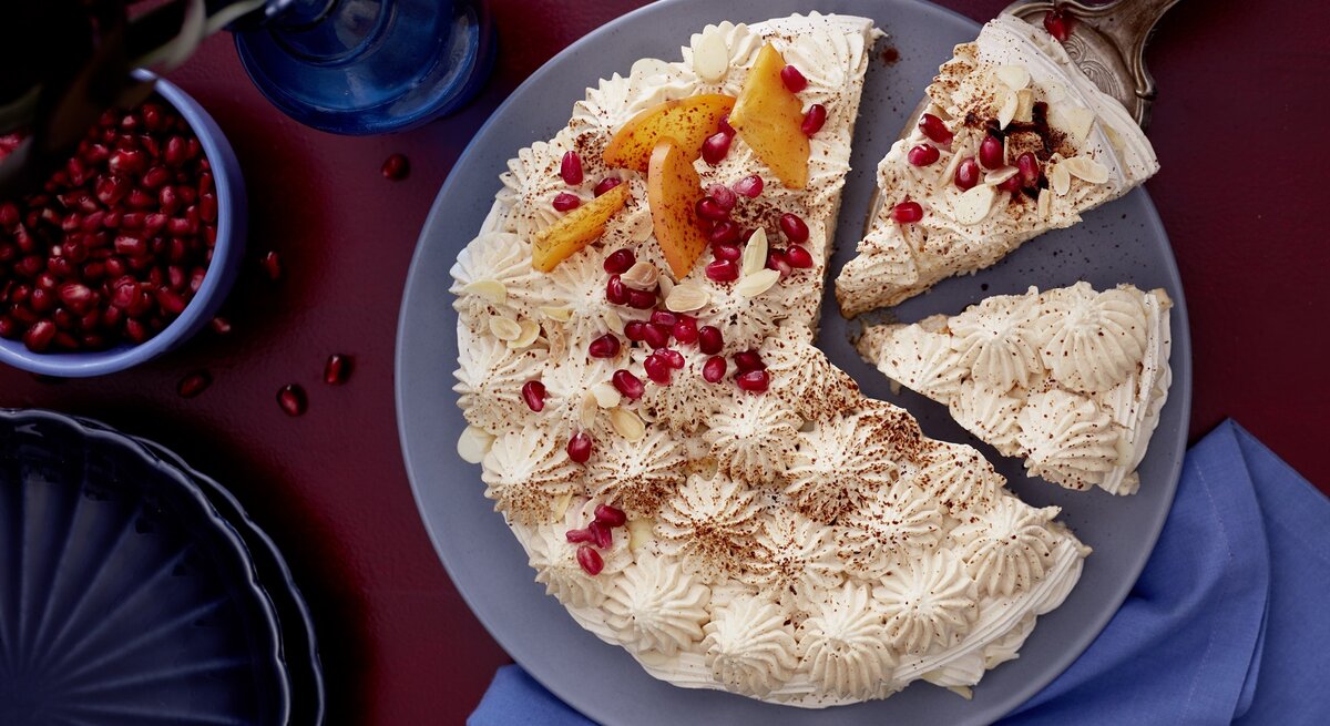 Die Mokka-Baiser-Joghurttorte auf einem dunkelblauem Teller und Untergrund. Direkt von oben fotografiert.