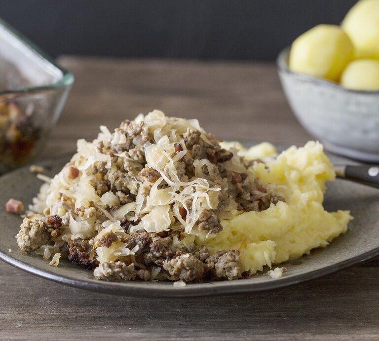Ein grauer Teller mit dem Gericht auf einem rustikalen Holztisch. Alles von der Seite fotografiert. | © StockFood/Godt, Nicole