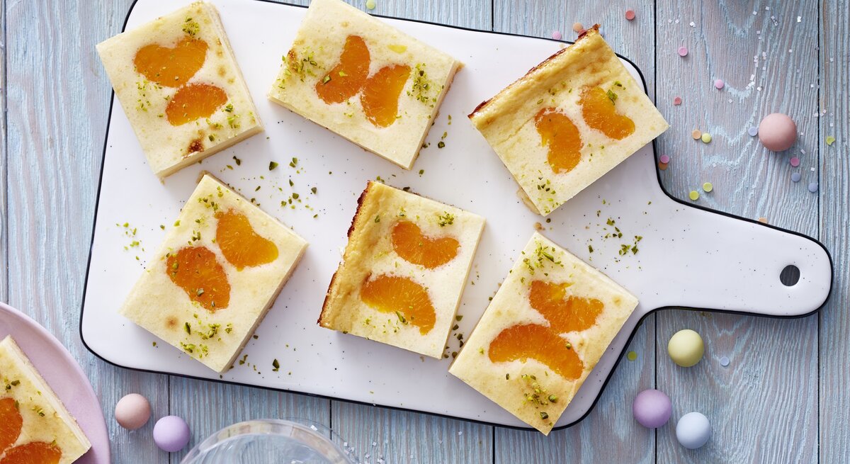 Schmetterlings-Käsekuchen auf einem weißen Schneidebrett vor grauem Hintergrund. 