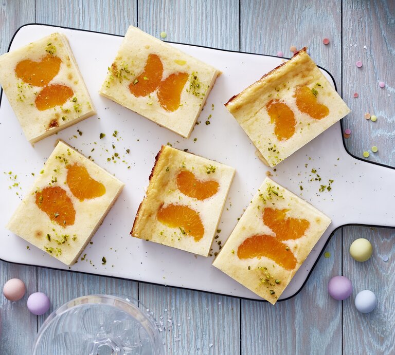 Schmetterlings-Käsekuchen auf einem weißen Schneidebrett vor grauem Hintergrund.  | © Isabell Triemer