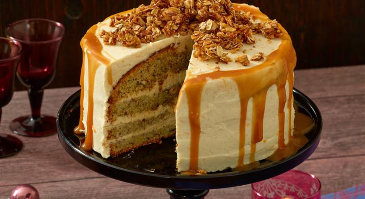 Karamell-Knusper-Torte / angeschnitten / runde Tortenplatte auf Tisch / Untergrund Holzplanken / Draufsicht leicht schräg