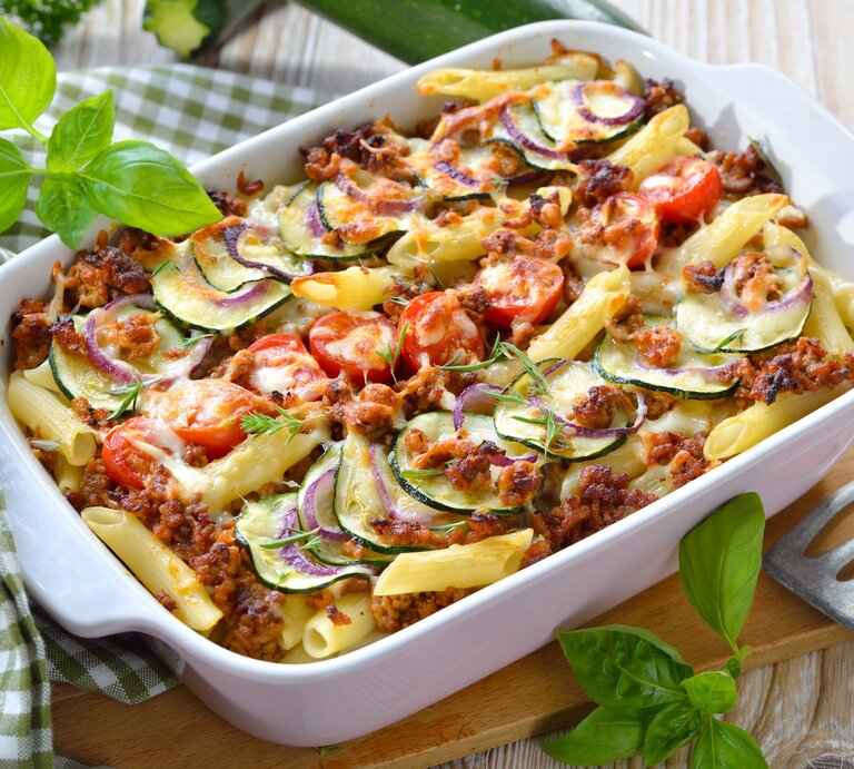 Weiße Auflaufform gefüllt mit traditioneller Penne al forno – lecker mit Hack und Zucchini! | © iStock/kabVisio