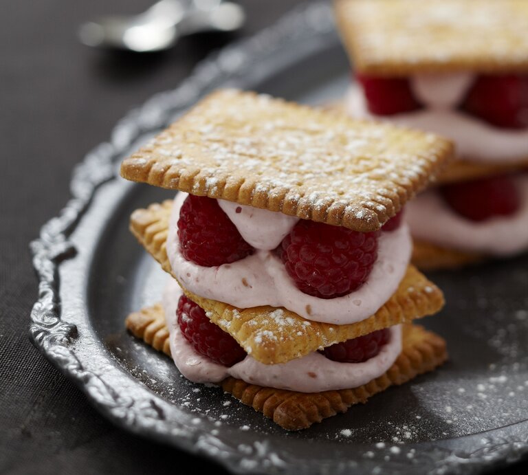 Butterkeks-Lasagne mit Mascarponecreme und Erdbeeren auf Tablett aus Metall; Frontale Ansicht | © StockFood