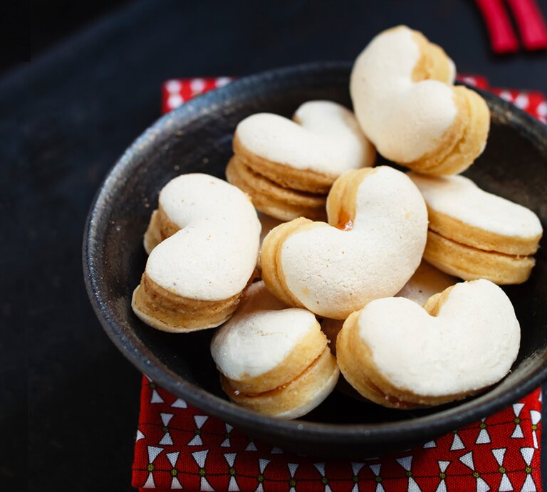 Herzförmige Baiser-Plätzchen in schwarzer Schale.  | © StockFood / Sporrer/Skowronek