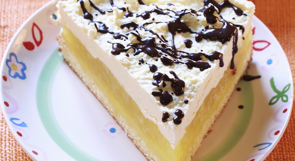 Der Apfelkuchen auf einem bunten Teller mit Schokosoße.