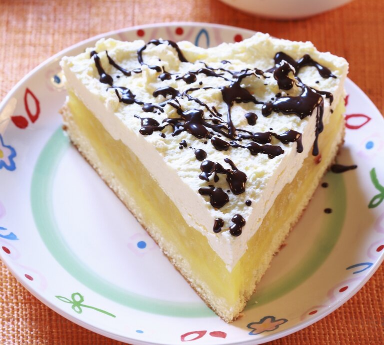 Der Apfelkuchen auf einem bunten Teller mit Schokosoße. | © StockFood / Bialy, Boguslaw