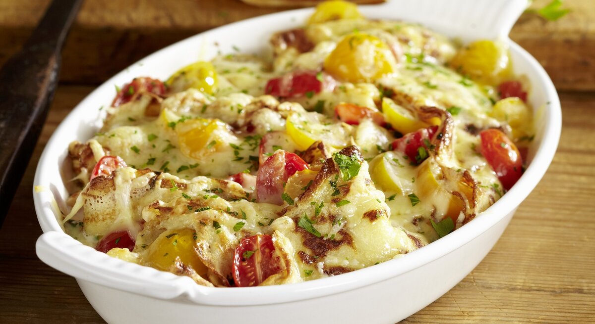 Der Schweizer Auflauf Sittertobelmahl in einer ovalen Form. Untergrund Holz / Draufsicht, leicht schräg von oben.