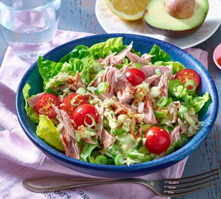 Thunfisch-Avocado-Salat in runder Schüssel / Gabel / halbe Avocado mit Kern / Serviette aus Stoff | © Matthias Liebich