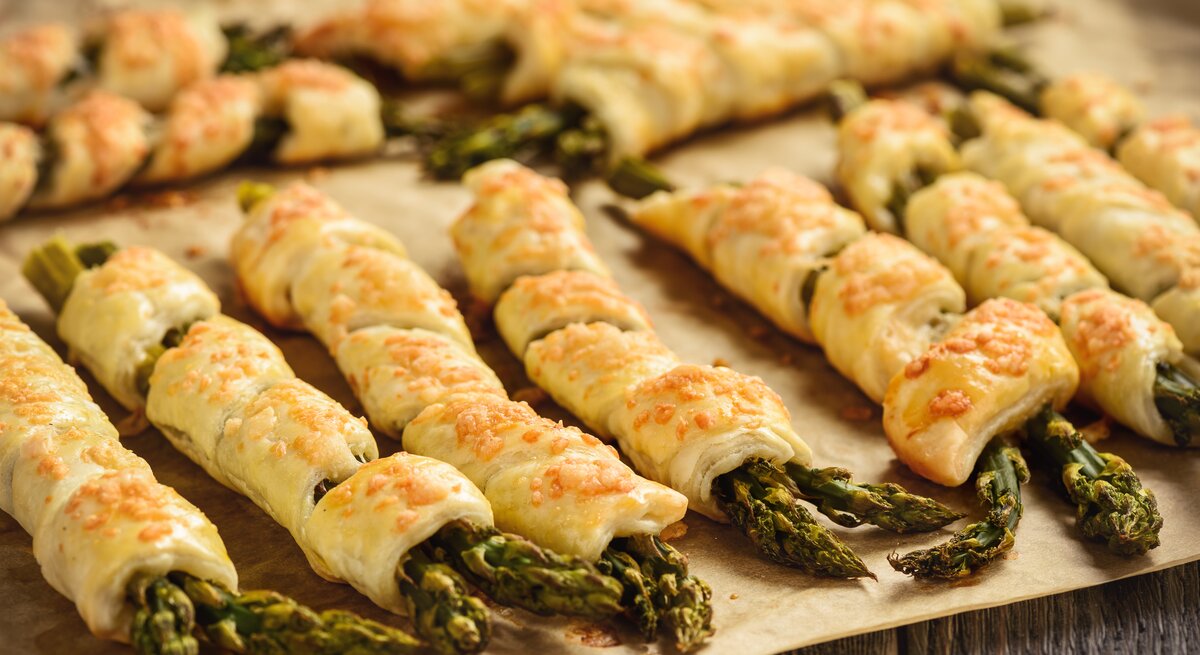 Grüner Spargel in Blätterteigmanten gewickelt. 