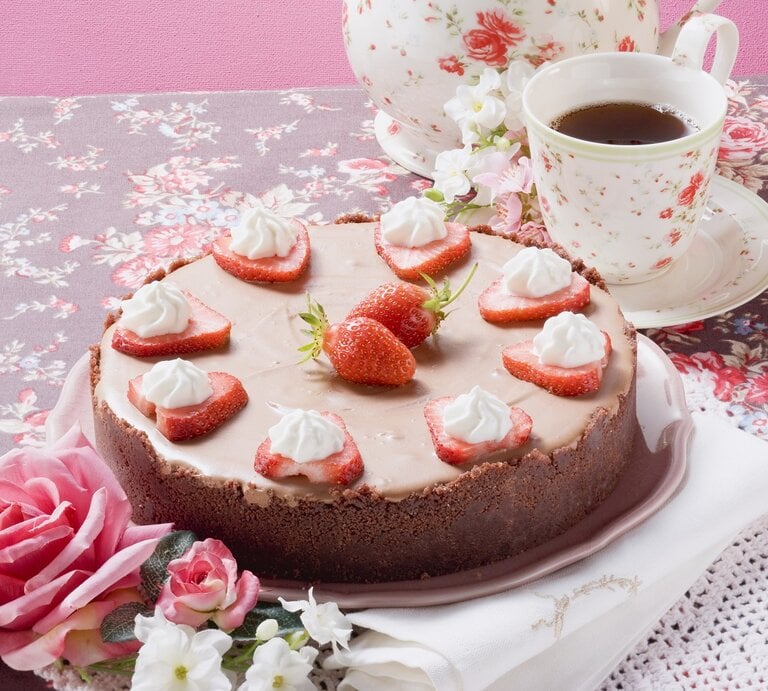 Die Torte auf einem Tisch mit Blumentischdecke. Alles von schräg oben fotografiert. | © StockFood / Eising Studio - Food Photo & Video
