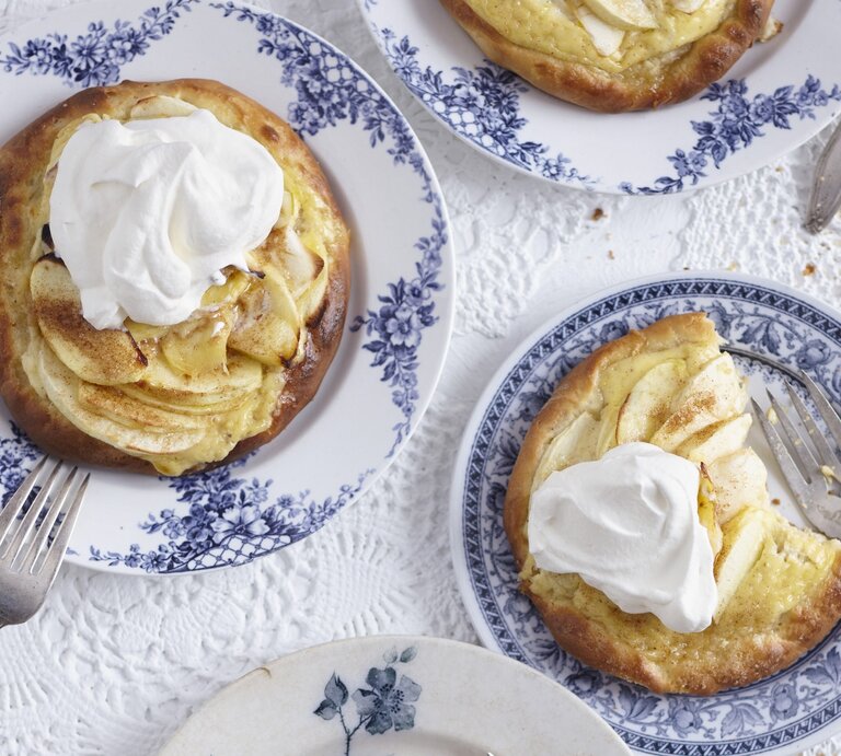 Die Apfel-Pizetten auf blau-weißen Tellern und weißer Tischdecke. Alles direkt von oben fotografiert. | © StockFood / ZS/Schtz, Anke