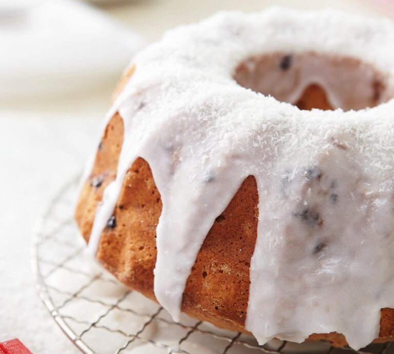 Der Napfkuchen mit Rhabarber und Kokos auf einem Metallgitter und hellem Holztisch. | © StockFood/Kirchherr, Jo