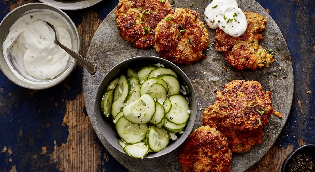 Brot-Fikadellen mit Gurkensalat auf hölzernem Hintergrund.