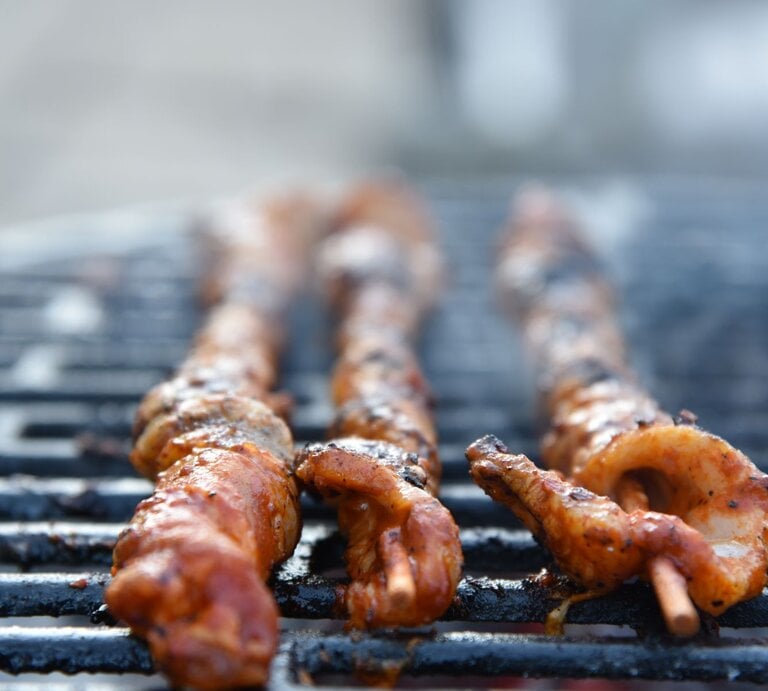 Selbst gemachte Grillfackeln mit Paprikamarinade beim Grillen auf einem Grillrost. Außenaufnahme. Frontalansicht. | © Shutterstock / knipsdesign