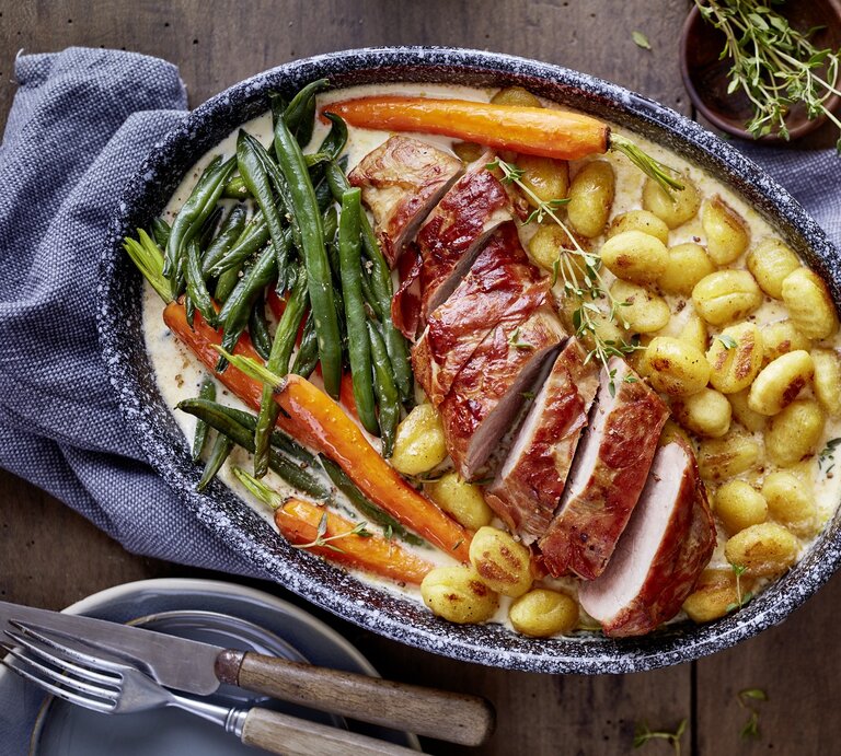 In Rahmsoße gebackenes Schweinefilet mit Gnocchi, glasierten Möhren und grünen Bohnen in rustikaler Auflaufform. | © EAT CLUB / Isabell Triemer