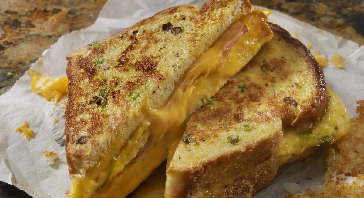 Das Arme-Ritter-Sandwich auf Küchenapier und einem Marmortisch.