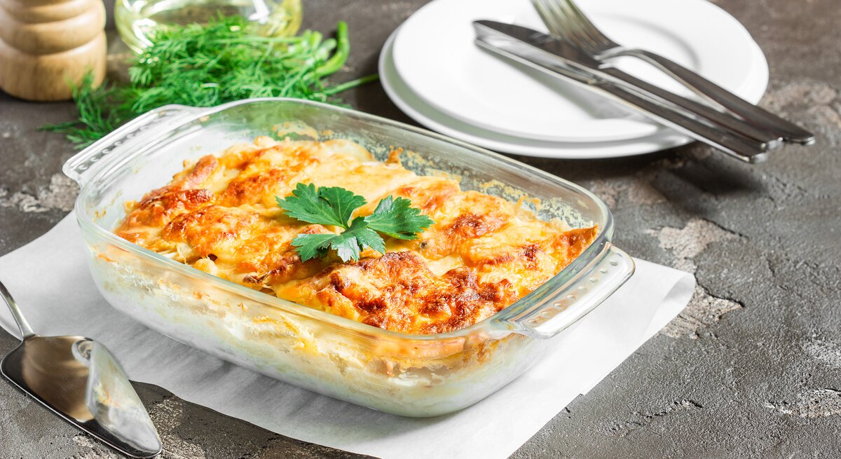Durchsichtige Auflaufform gefüllt mit Kartoffelauflauf, überbacken mit krosser Käsekruste.