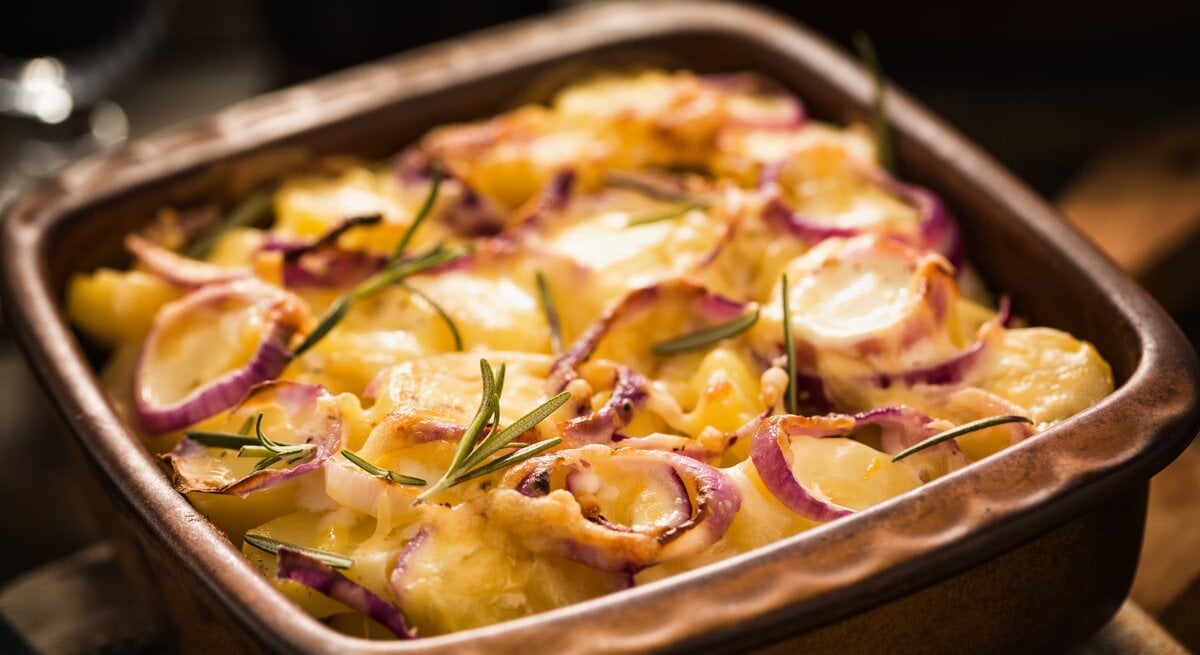 Das Kartoffelgratin mit Hackfleisch auf einem Holztisch.