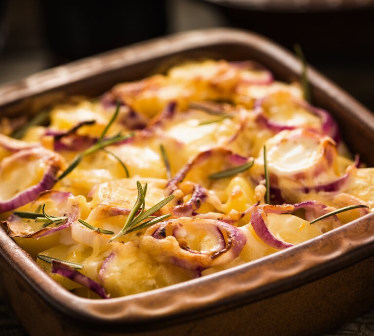 Das Kartoffelgratin mit Hackfleisch auf einem Holztisch. | © iStock/GMVozd