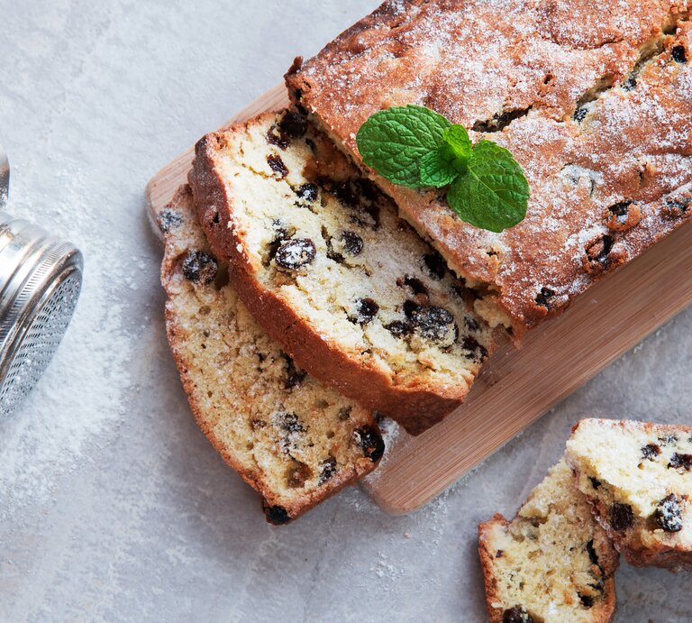 Draufsicht auf einen angeschnittenen Kastenkuchen mit Rosinen. | © iStock/ Martysjahlushyk