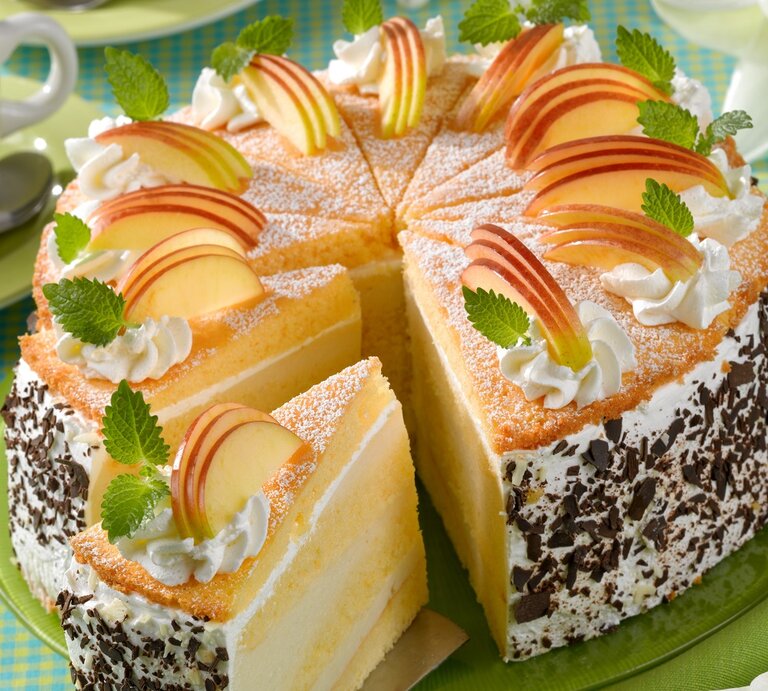 Die Apfelcreme-Schichttorte auf einem Tisch mit hellgrüner Tischdecke von schräg oben fotografiert. | © Matthias Liebich