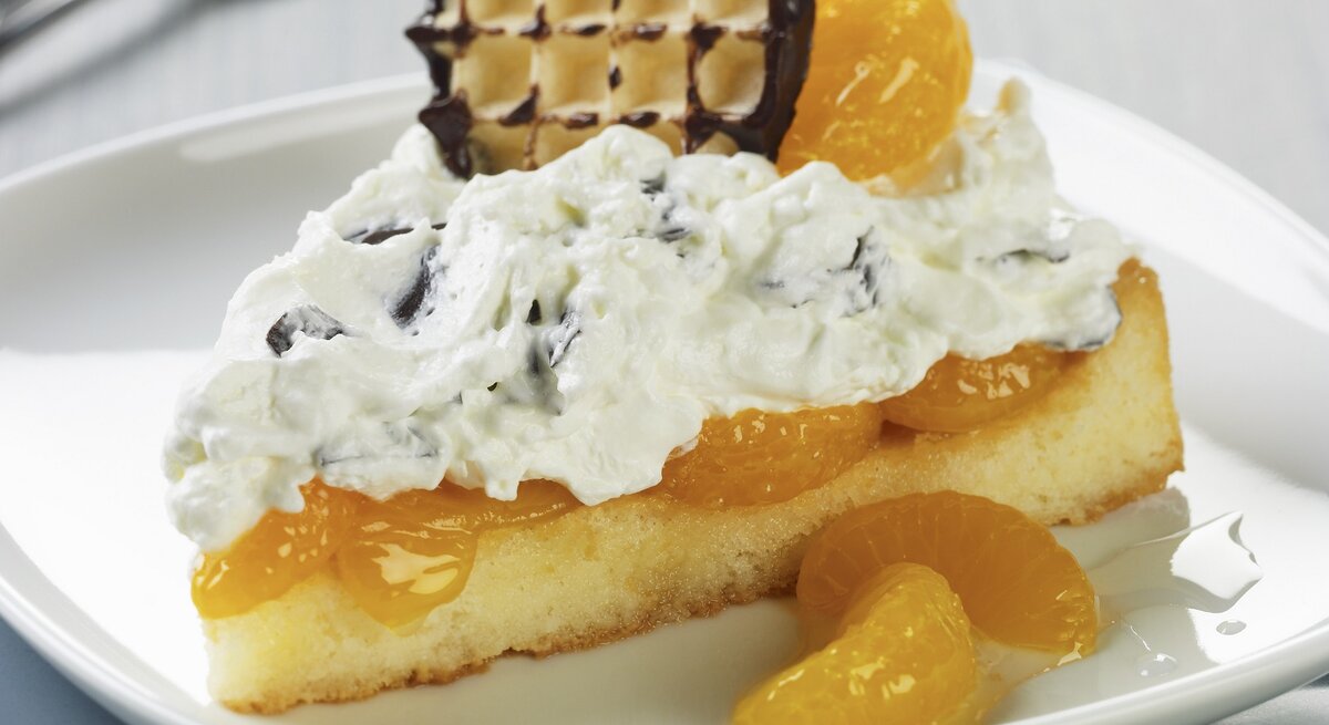 Schokokuss-Biskuittorte mit Mandarinen / ein Stück / runder teller / Kuchengabel / Nahaufnahme / Draufsicht schräg