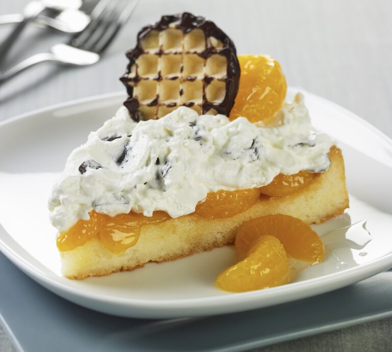 Schokokuss-Biskuittorte mit Mandarinen / ein Stück / runder teller / Kuchengabel / Nahaufnahme / Draufsicht schräg | © StockFood
