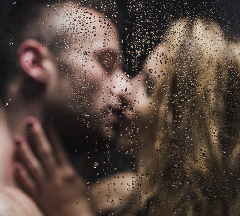 Ein küssendes Paar, das unter der Dusche steht | © iStock/KatarzynaBialasiewicz