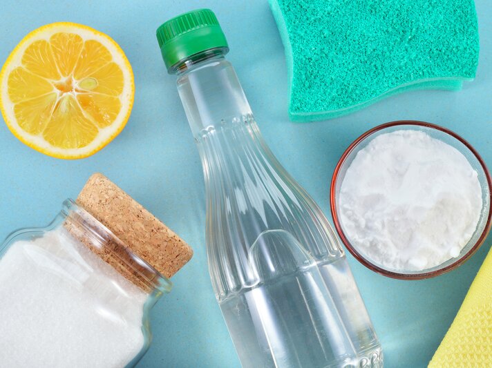 Verschiedene Hausmittel, zum Beispiel eine Flasche Essig und Backpulver. | © iStock / Geo-grafika